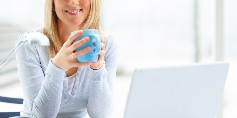 Portrait of mature business woman with a laptop and drinking cof